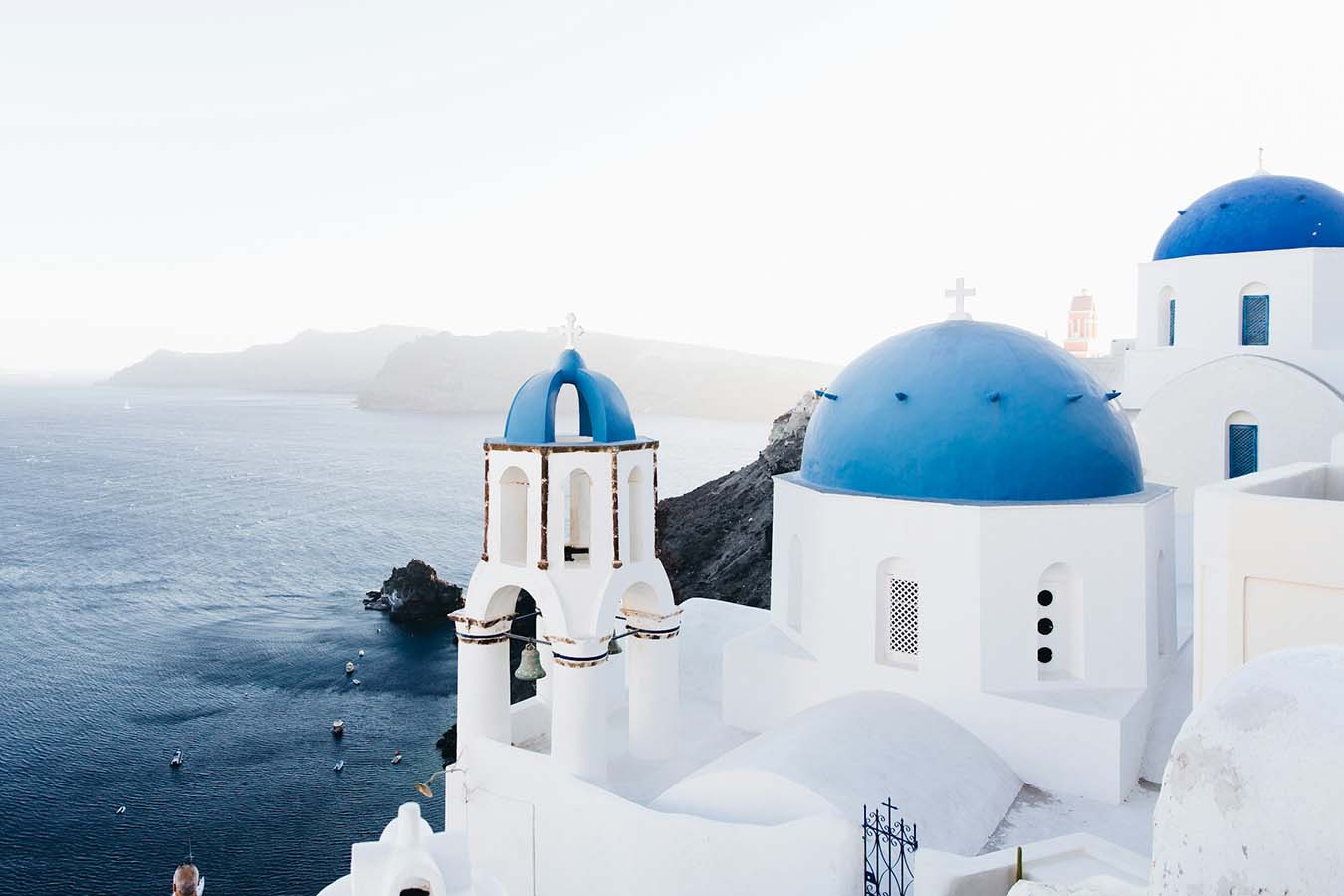 Santorini Greece caldera at sunset with white buildings cascading down the cliff